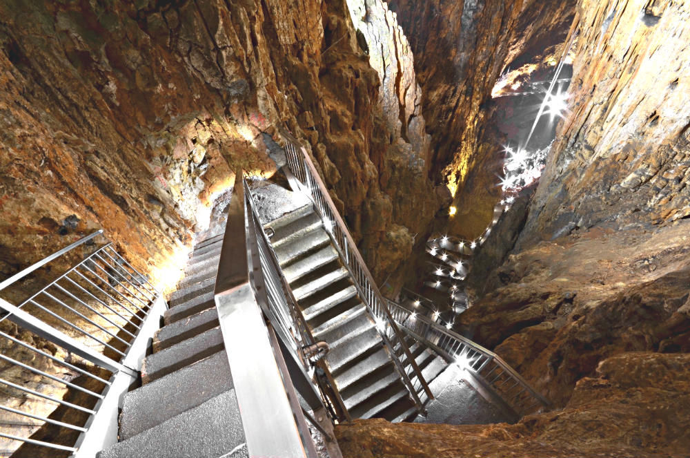 La scalinata illuminata che scende nella grotta
